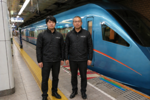 列車の前で写真を撮る二人の男性
