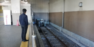 列車の車両止めを見つめる男性の画像